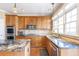 This lovely kitchen features granite counters, wood cabinets and backsplash, and stainless steel appliances at 775 River Cliff Ct, Suwanee, GA 30024