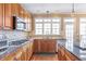 This lovely kitchen features granite counters, wood cabinets and backsplash, and stainless steel appliances at 775 River Cliff Ct, Suwanee, GA 30024