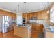 Charming kitchen featuring wood cabinets, granite countertops, stainless steel appliances, and a kitchen island at 775 River Cliff Ct, Suwanee, GA 30024