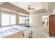 Bright main bedroom features tray ceiling, ceiling fan, and a bay window with plantation shutters at 775 River Cliff Ct, Suwanee, GA 30024