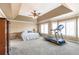 Large main bedroom featuring a tray ceiling, ceiling fan, and a bay window with plantation shutters at 775 River Cliff Ct, Suwanee, GA 30024