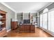 Well-lit home office with hardwood floors, built-in shelving, crown molding, and large windows at 775 River Cliff Ct, Suwanee, GA 30024