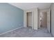 A bedroom with plush carpeting, blue accent wall, closet and a view of the open doorway at 55 Burns View Ct, Lawrenceville, GA 30044