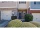 Townhome exterior featuring a stone facade, one-car garage, and attractive landscaping at 55 Burns View Ct, Lawrenceville, GA 30044