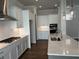 Modern kitchen with white cabinets, quartz counters, and herringbone backsplash at 140 Birch Tree Way, Cumming, GA 30040