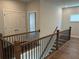 Upstairs hallway with wood floors, double doors, and a modern railing at 140 Birch Tree Way, Cumming, GA 30040