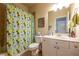 Bathroom featuring white vanity, shower/tub combo and bright blue shower curtain at 2240 Palmour Ct, Atlanta, GA 30337