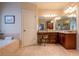 Bathroom with dual vanity and granite countertops, soaking tub with tile surround at 2240 Palmour Ct, Atlanta, GA 30337