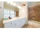 Bathroom featuring white cabinets, a shower/tub combo and window with plantation shutters at 2240 Palmour Ct, Atlanta, GA 30337