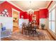 Elegant dining room featuring a chandelier, wainscoting, red accent wall, and ample natural light at 2240 Palmour Ct, Atlanta, GA 30337