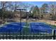 Well-maintained blue and green community tennis courts surrounded by mature trees in a fenced in area at 2240 Palmour Ct, Atlanta, GA 30337