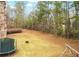 Large, grassy backyard featuring mature trees, a small retaining wall, and a trampoline at 110 Robinwood Ct, Fayetteville, GA 30214