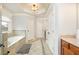 Bright bathroom features a soaking tub, tiled floors, and natural light from a window with privacy blinds at 110 Robinwood Ct, Fayetteville, GA 30214