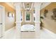 Bathroom featuring a luxurious tub with pillars, decorative lighting, and a large window for natural light at 110 Robinwood Ct, Fayetteville, GA 30214