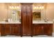 Elegant bathroom with double vanities featuring dark wood cabinets, granite countertops, and large mirrors at 110 Robinwood Ct, Fayetteville, GA 30214