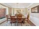 Bright dining room with wood table and chairs, decorative chandelier, and large window at 4035 Powerscourt Pl, Suwanee, GA 30024