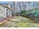 Landscaped backyard featuring a wooden deck with seating and a serene view of mature trees at 976 Forest Pond Cir, Marietta, GA 30068