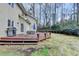 Backyard with wooden deck, grill, outdoor seating, mature trees, and well-maintained lawn at 976 Forest Pond Cir, Marietta, GA 30068