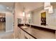 Bathroom vanity with dark countertop and white cabinets, illuminated by pendant lighting at 976 Forest Pond Cir, Marietta, GA 30068