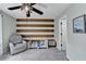 Neutral bedroom with wood accent wall, ceiling fan, and seating at 976 Forest Pond Cir, Marietta, GA 30068