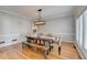 Traditional dining room with a long wooden table, bench seating, hardwood floors and decorative hanging light fixture at 976 Forest Pond Cir, Marietta, GA 30068