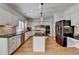 Traditional kitchen with island, white cabinets, black countertops, stainless appliances and lots of workspace at 976 Forest Pond Cir, Marietta, GA 30068