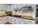 Traditional kitchen with stainless appliances, black countertop, gas range and natural tile backsplash at 976 Forest Pond Cir, Marietta, GA 30068