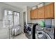 Bright laundry room with modern washer, dryer, window, and overhead cabinets at 976 Forest Pond Cir, Marietta, GA 30068