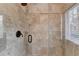 Elegant tiled shower with glass enclosure, window, and bronze fixtures at 976 Forest Pond Cir, Marietta, GA 30068