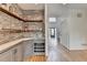 Stylish wet bar with stone wall, open shelves, wine rack, and a view to the front door at 976 Forest Pond Cir, Marietta, GA 30068