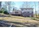 Backyard view of the multi-story home, including deck, lawn, and brick exterior at 2265 Pine Point Dr, Lawrenceville, GA 30043