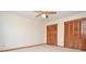 Bedroom featuring neutral carpet, fan, and dual closets with wood-slat doors at 2265 Pine Point Dr, Lawrenceville, GA 30043