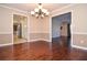 Dining area showcasing beautiful hardwood floors, crown molding, and a modern chandelier at 2265 Pine Point Dr, Lawrenceville, GA 30043