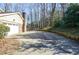 Long driveway leading to a spacious garage and a lush, wooded backyard at 2265 Pine Point Dr, Lawrenceville, GA 30043