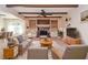 Digitally staged living room featuring a fireplace, custom built-ins, beamed ceilings and overhead fan at 2265 Pine Point Dr, Lawrenceville, GA 30043