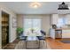 Virtually staged dining area with table, chairs, modern lighting and view of kitchen at 2600 Burkshire Rd, Ellenwood, GA 30294