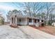 Single-story brick home with a carport and a white picket fence in a suburban neighborhood at 2600 Burkshire Rd, Ellenwood, GA 30294