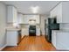 Bright kitchen with granite counters, black appliances, white cabinets, and wood flooring at 2600 Burkshire Rd, Ellenwood, GA 30294