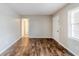 Empty living room featuring wood flooring, neutral walls and a window with white blinds at 2600 Burkshire Rd, Ellenwood, GA 30294