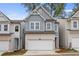 Two-story townhome with gray siding, white trim, and a two-car garage at 702 Smokey Quartz Way, Kennesaw, GA 30144