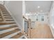 Modern light oak staircase with black balusters and view into the living room and kitchen at 702 Smokey Quartz Way, Kennesaw, GA 30144