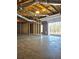 Unfinished basement with concrete floor, exposed ceiling, framing, and open garage door at 866 Lee Byrd Rd, Loganville, GA 30052