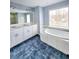 Bright bathroom featuring a soaking tub, double vanity, and blue-tiled floor at 866 Lee Byrd Rd, Loganville, GA 30052