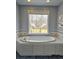 Relaxing bathroom with a soaking tub set against a picturesque window view at 866 Lee Byrd Rd, Loganville, GA 30052