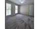Bedroom featuring neutral walls, two windows, and carpeting at 866 Lee Byrd Rd, Loganville, GA 30052