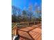 Spacious wood deck with black metal railing overlooking a lush backyard with mature trees on a sunny day at 866 Lee Byrd Rd, Loganville, GA 30052