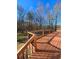 View of wood deck with railings offering a glimpse of the wooded backyard and clear blue skies at 866 Lee Byrd Rd, Loganville, GA 30052