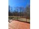 Wood deck with black railings and a backyard filled with trees and vegetation in this outdoor space at 866 Lee Byrd Rd, Loganville, GA 30052