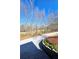 Gravel driveway flanked with garden bed, tree line, and greenery on a sunny day at 866 Lee Byrd Rd, Loganville, GA 30052