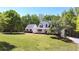Charming two-story white home boasts a well-manicured lawn, complemented by mature trees and a welcoming front porch at 866 Lee Byrd Rd, Loganville, GA 30052
